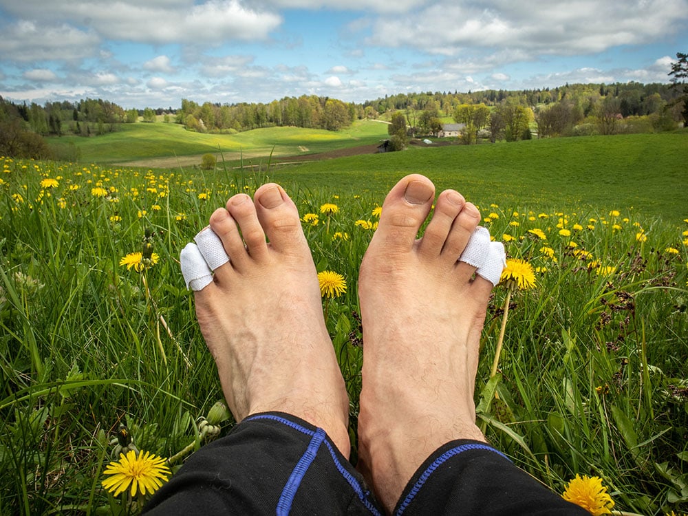 A man with taped bare feet while hiking