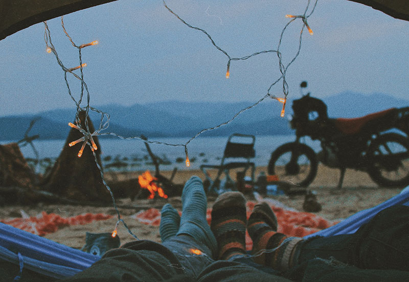 A couple chilling in a tent wearing socks