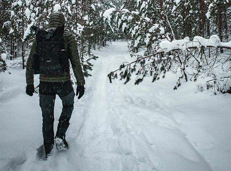 hiker walking in snowy forest