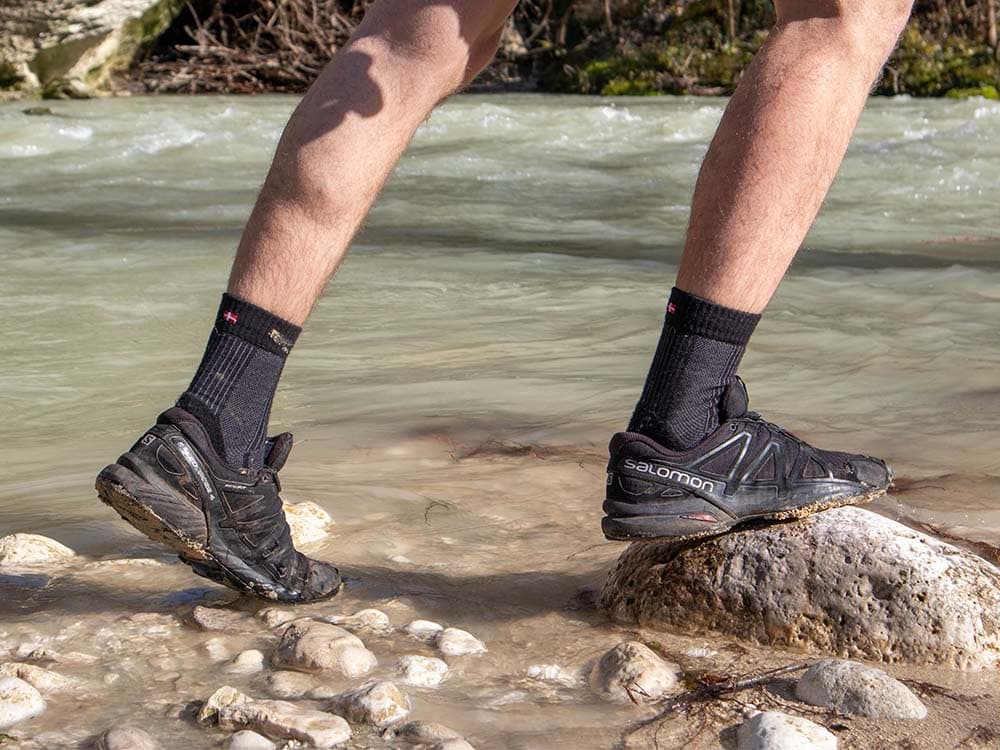 Wearing trail runners and hiking socks near a river