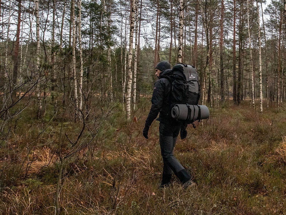 A man hiking cross-country in the forest