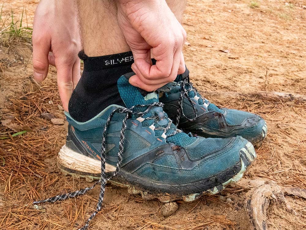 A hiker putting on no show hiking socks with trail runners