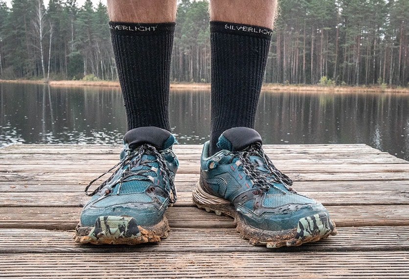 Showing the long, crew model of the silverlight hiking socks together with trail running shoes